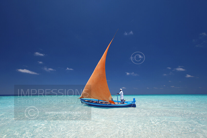 Maldives Traditional dhoni boat sailing on blue lagoon