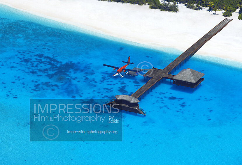 aerial view of seaplane moored at a Maldives resort jetty in blue lagoon