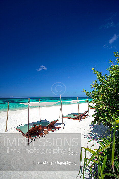 maldives stock sun loungers under beach huts on tropical beach