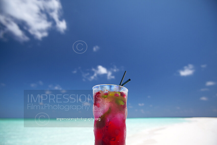 Maldives cocktail on the beach with blue lagoon stock photo