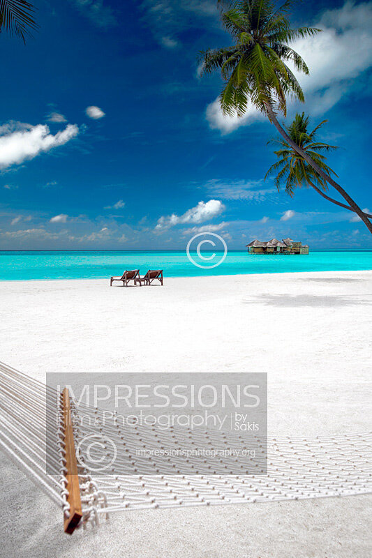 Maldives Hammock on a tropical beach of a luxury resort with views at water villas and blue lagoon stock photo