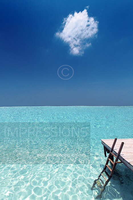 Maldives stock photo of ladder leading to ocean from a water villa wooden deck