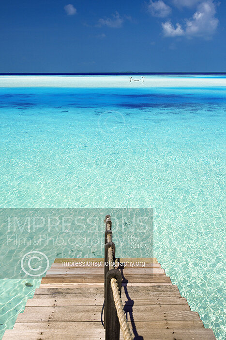 Maldives stock photo of ladder leading to ocean from a water villa wooden deck