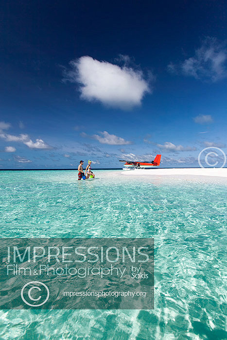 couple snorkeling in Maldives lagoon near a sandbank with seaplane