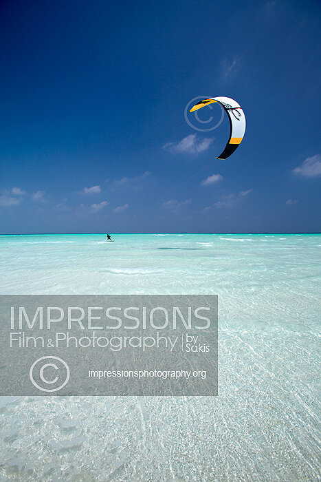 man or woman kitesurfing in Maldives on a blue lagoon Maldives stock photo