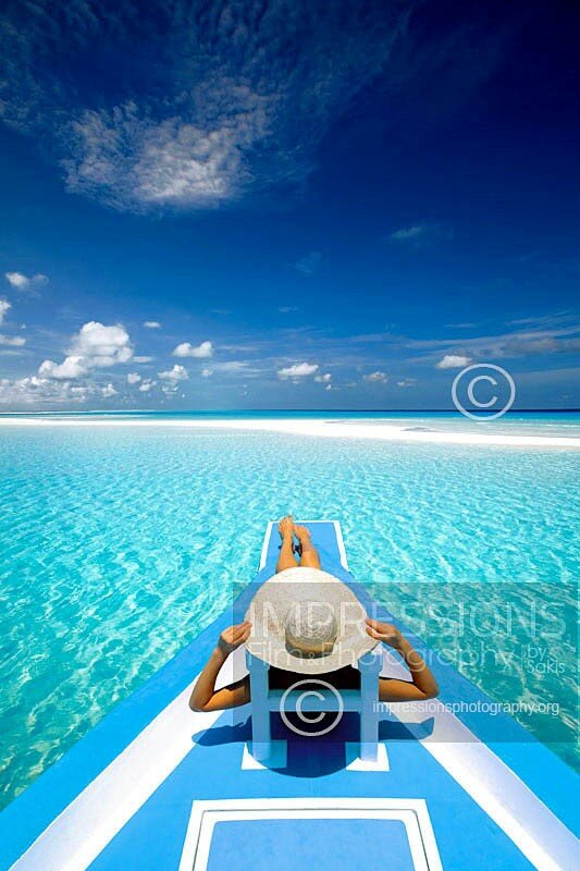 Woman relaxing on deck of a traditional Maldivian dhoni boat looking at the ocean Maldives stock photo