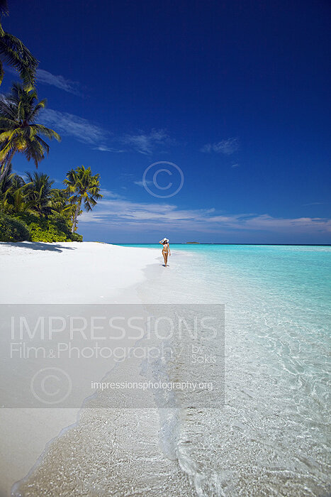 Young woman walking on a tropical beach, maldives