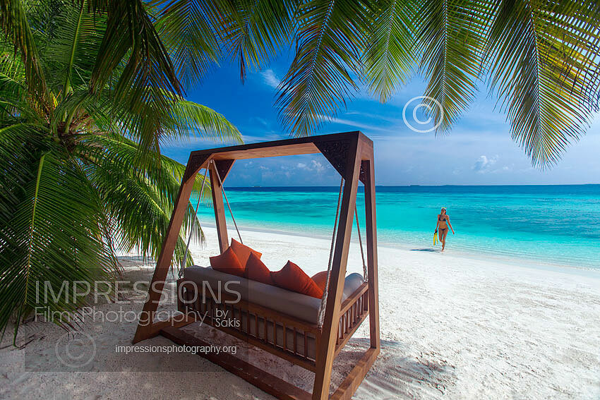 Swing on a Maldives tropical Beach and woman snorkeling