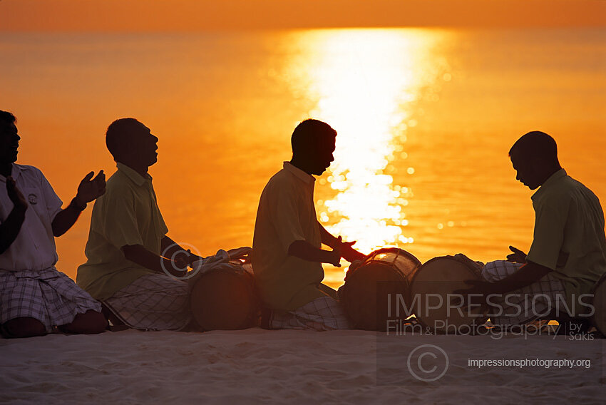 maldives stock photo traditional Maldivian Bodu Beru Drummers playing at sunset at the Beach