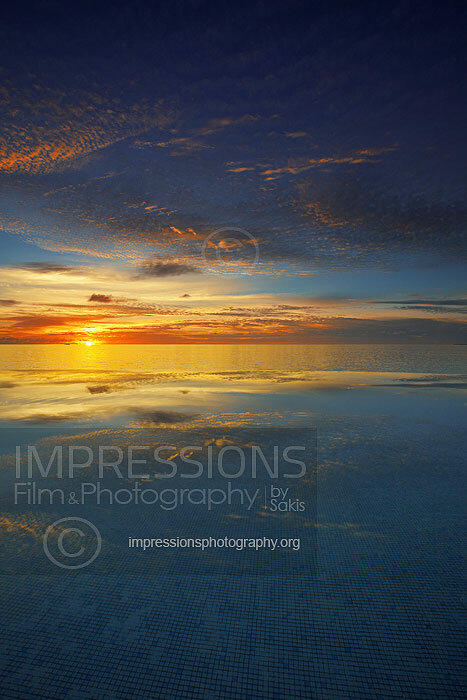 Maldives sunset from infinity pool with reflection and ocean views stock photo
