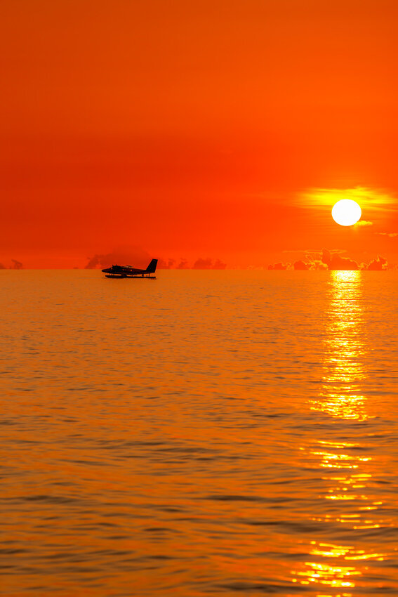 Maldives stock photo seaplane floating on ocean at sunset