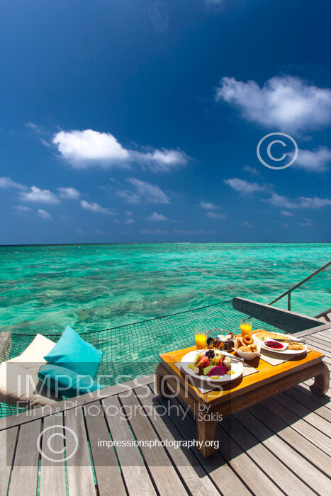 Maldives, overwater Hammock bed hanging over turquoise blue lagoon with breakfast setting in luxury resort stock photo