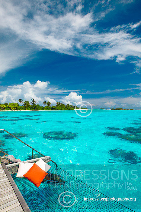 Maldives, overwater Hammock bed hanging over turquoise blue lagoon with view at tropical island in luxury resort stock photo