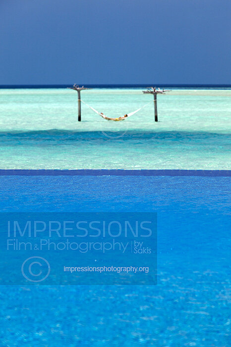 Maldives, woman relaxing in water hammock in turquoise blue lagoon Stock Photo