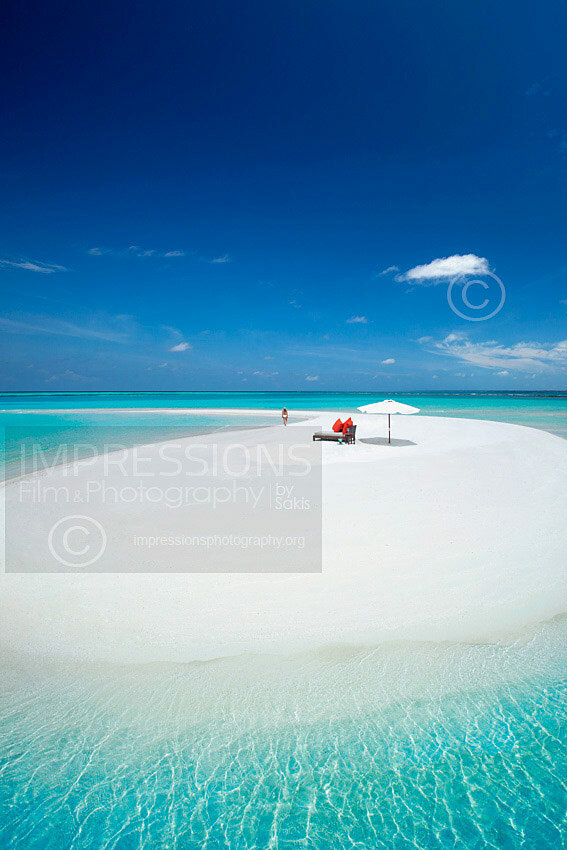 maldives woman walking on a sandbank with luxury lounge sofa and sun umbrella stock photo