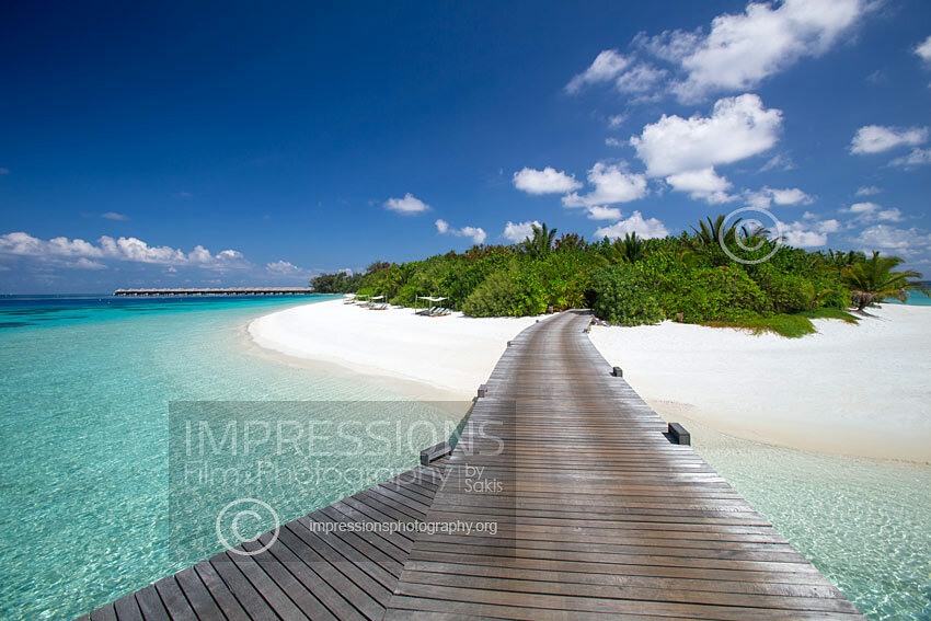 Maldives stock photo of a wooden jetty leading to a tropical island over blue lagoon