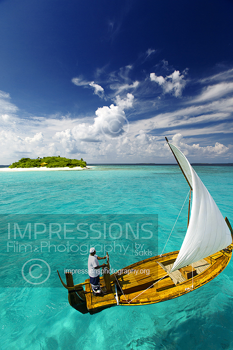 Sailing with traditional dhoni and tropical island, Maldives stock photo