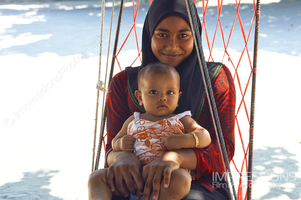 photo of a smiling mother and her young baby girl in a joali on a Maldives local island