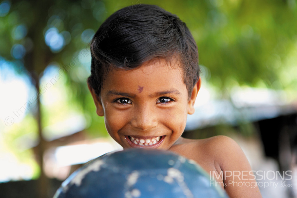 portrait of a young boy with a football ball on Maldives local island - photos of the people of Maldives series